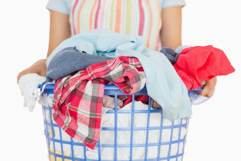 woman holding laundry basket full of clothes