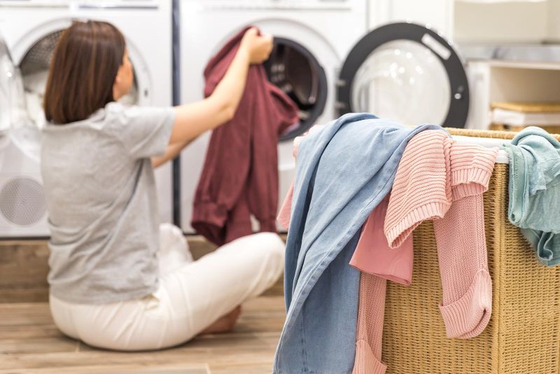 woman sitting on floor doing laundry